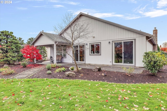 rear view of house with a lawn and a patio