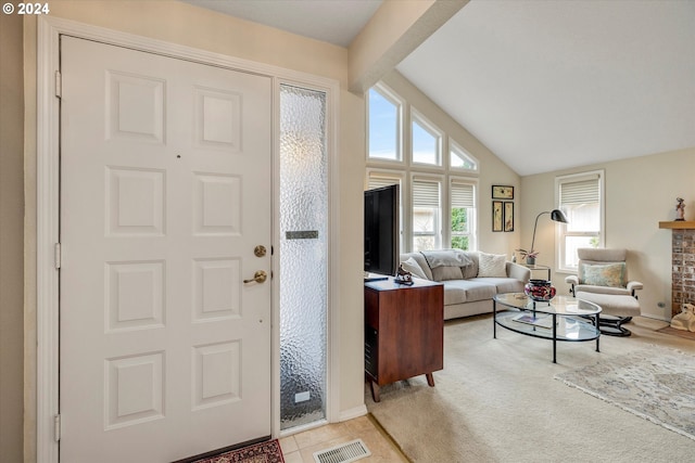 carpeted foyer featuring lofted ceiling