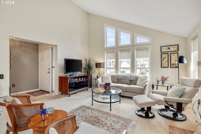 living room featuring plenty of natural light, carpet floors, and high vaulted ceiling