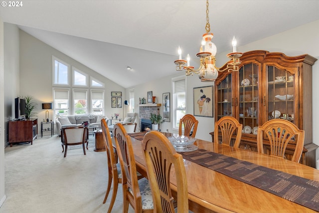 carpeted dining area with an inviting chandelier and vaulted ceiling