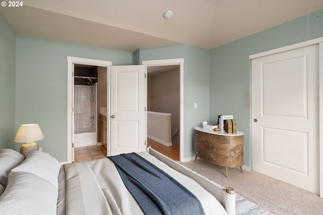 bedroom with connected bathroom and light tile floors