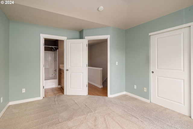 unfurnished bedroom featuring carpet, connected bathroom, and a closet