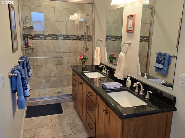 bathroom with tile patterned flooring, vanity, and a shower with shower door