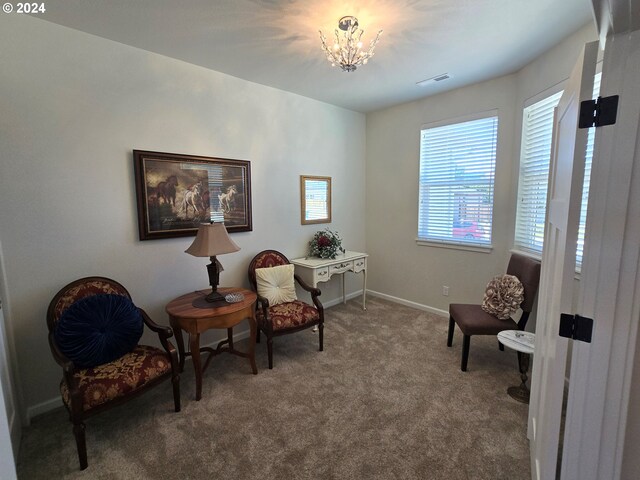 living area featuring carpet floors and a notable chandelier