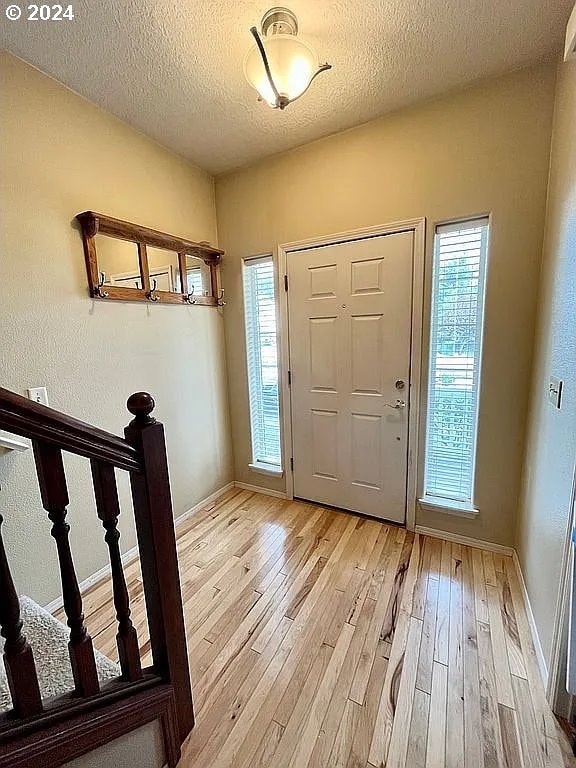 foyer with light hardwood / wood-style flooring and a textured ceiling