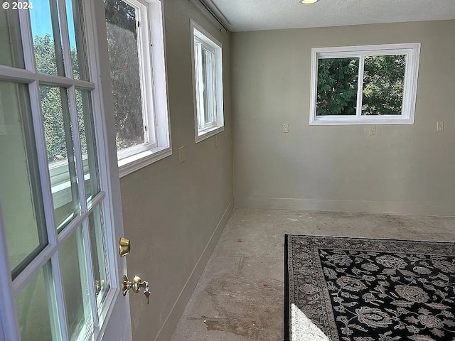 spare room featuring a textured ceiling and plenty of natural light