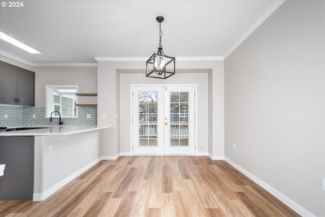 unfurnished dining area featuring light hardwood / wood-style flooring, a healthy amount of sunlight, french doors, and sink