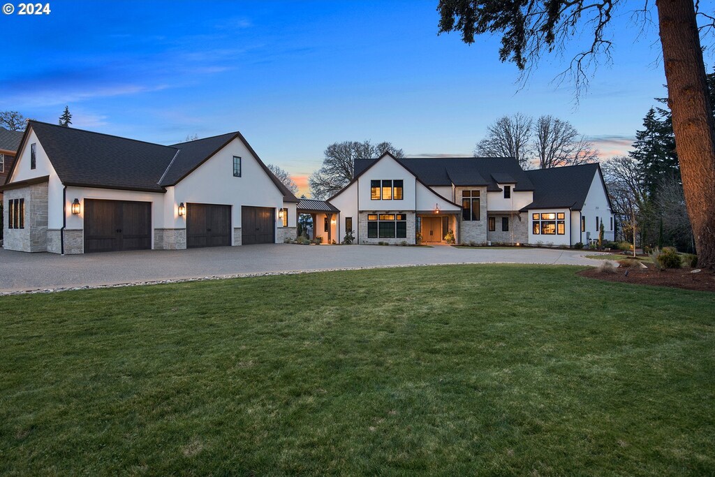 modern farmhouse with a yard and a garage