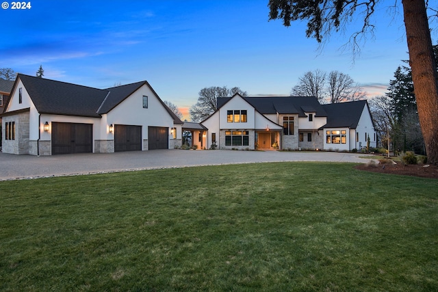 modern farmhouse with a yard and a garage