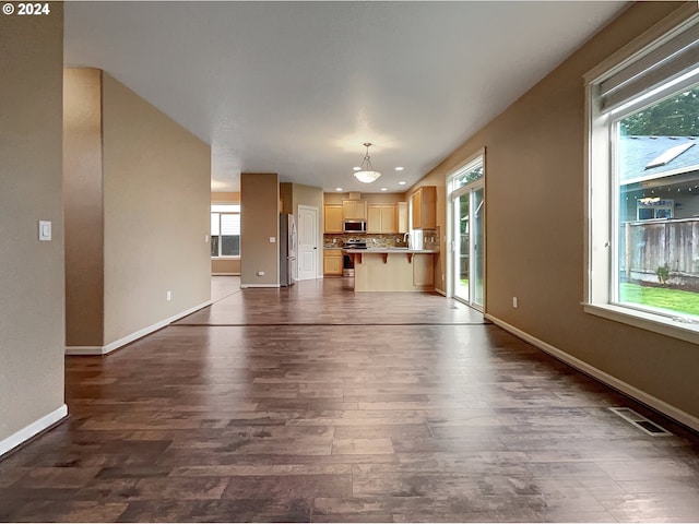 unfurnished living room with dark hardwood / wood-style flooring