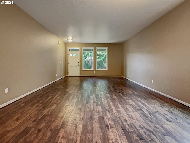 interior space featuring a textured ceiling and dark hardwood / wood-style flooring