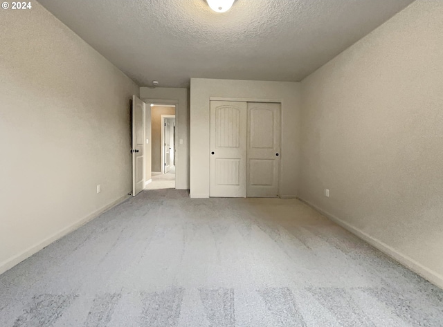 unfurnished bedroom featuring a closet, carpet floors, and a textured ceiling