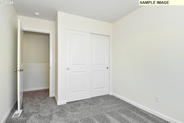 unfurnished bedroom with carpet flooring and a closet