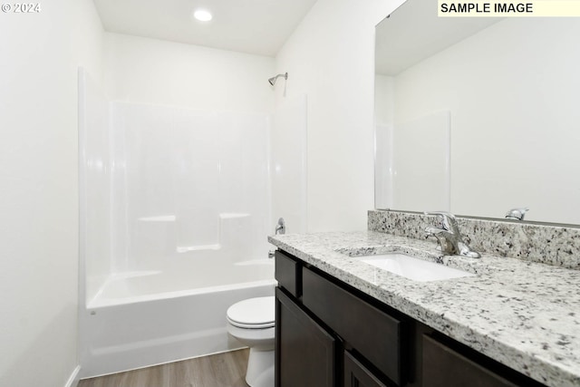 full bathroom featuring wood-type flooring, toilet, vanity, and  shower combination