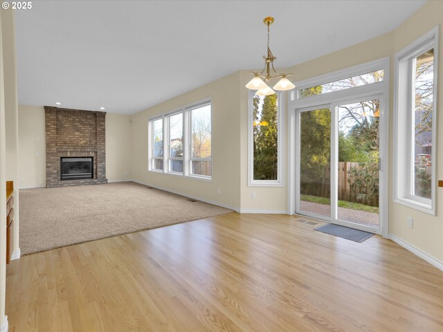 unfurnished living room featuring a fireplace, visible vents, light wood finished floors, and baseboards