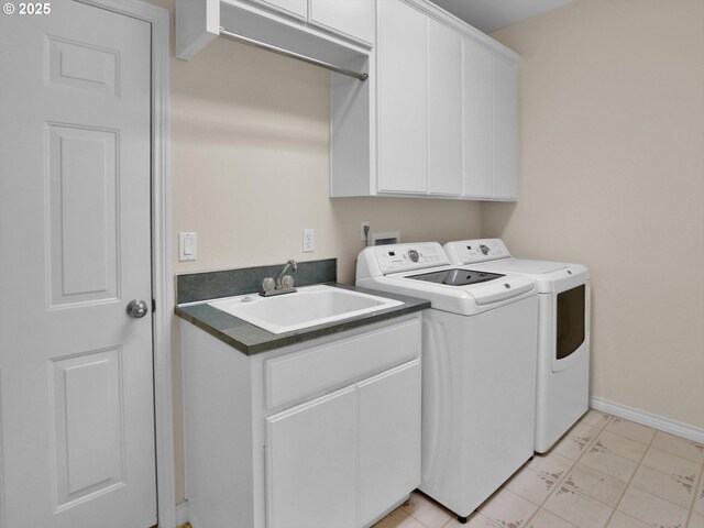 laundry area featuring separate washer and dryer, cabinet space, baseboards, and a sink