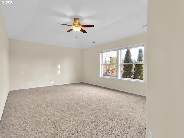 carpeted spare room with visible vents, ceiling fan, and baseboards