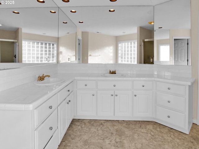 full bathroom featuring backsplash, recessed lighting, a stall shower, and vanity