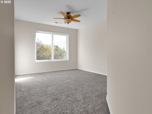 carpeted spare room featuring visible vents, baseboards, and a ceiling fan