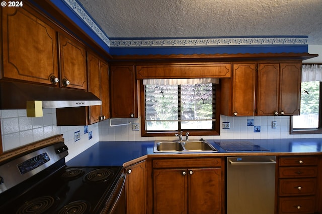 kitchen with tasteful backsplash, sink, stainless steel appliances, and a textured ceiling