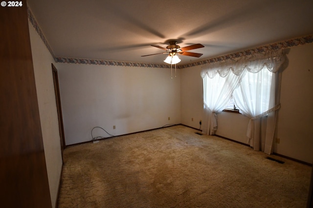 carpeted spare room featuring ceiling fan