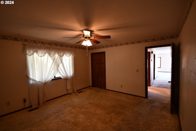 carpeted empty room featuring ceiling fan