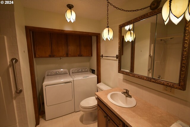 bathroom featuring walk in shower, vanity, toilet, and washer and dryer