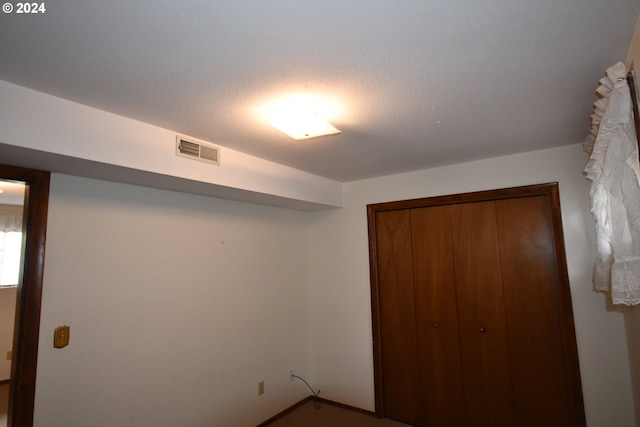 unfurnished bedroom featuring a closet and a textured ceiling