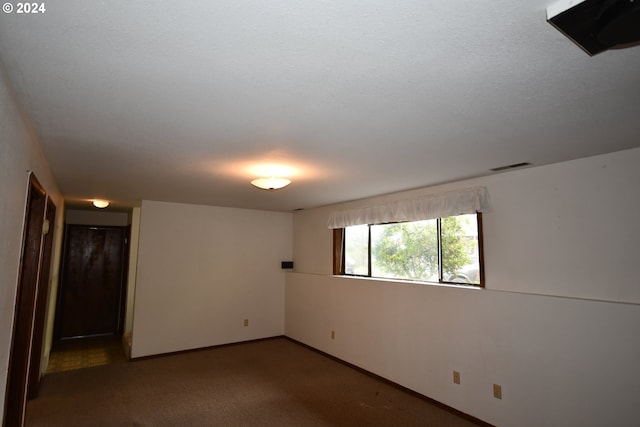 carpeted spare room with a textured ceiling