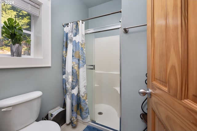 bathroom featuring a stall shower and toilet