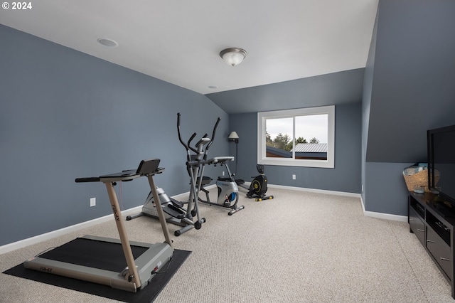 exercise room with lofted ceiling, carpet, and baseboards