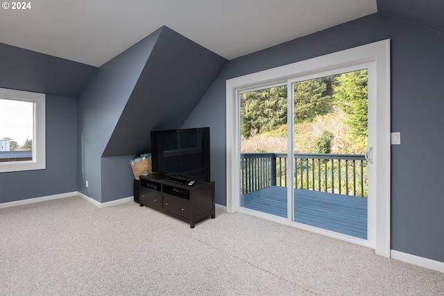 interior space with carpet flooring, vaulted ceiling, and baseboards