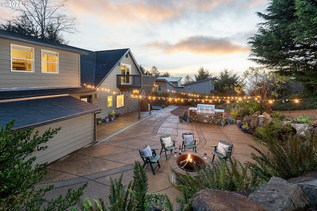 patio terrace at dusk with a balcony and a fire pit