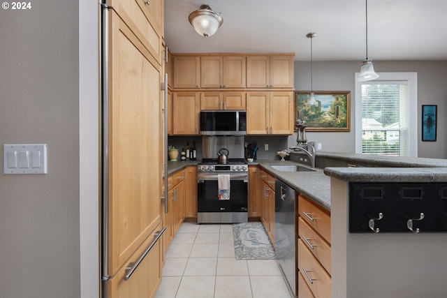 kitchen with light tile patterned floors, backsplash, appliances with stainless steel finishes, a sink, and a peninsula