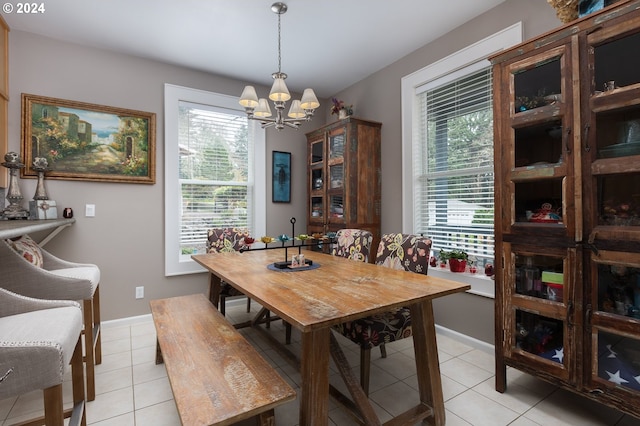 dining space with light tile patterned floors, baseboards, a notable chandelier, and a healthy amount of sunlight