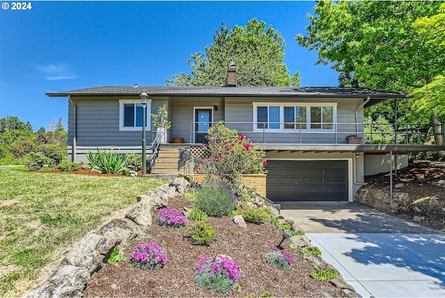 view of front of house with a porch, a garage, and a front lawn