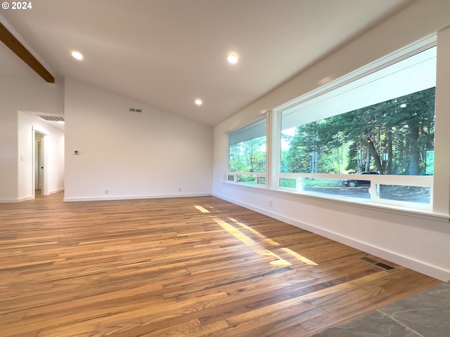 spare room featuring vaulted ceiling and hardwood / wood-style floors