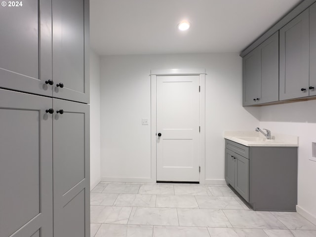 laundry room featuring sink, hookup for a washing machine, cabinets, and light tile patterned flooring