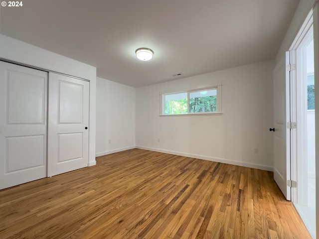 unfurnished bedroom with hardwood / wood-style floors and a closet