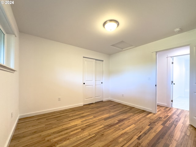 unfurnished bedroom with a closet and hardwood / wood-style floors