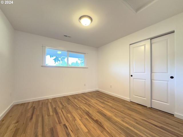 unfurnished bedroom featuring a closet and hardwood / wood-style floors