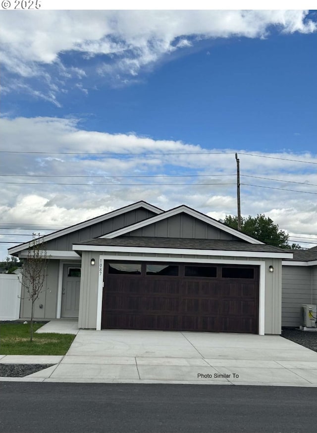 967 NE 11th St, Hermiston, OR 97838 - ranch-style home featuring board and batten siding, an attached garage, central air condition unit, and driveway