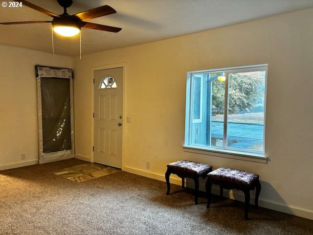 foyer with carpet floors and ceiling fan