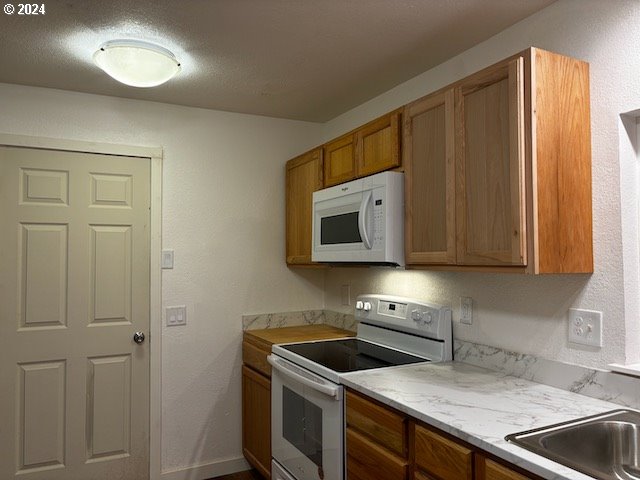 kitchen featuring white appliances and a textured ceiling