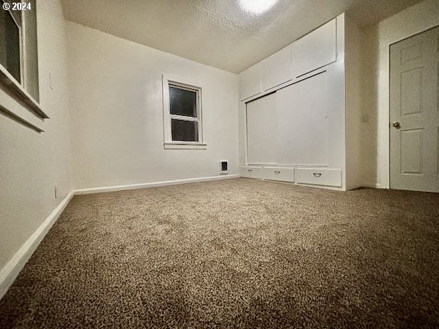 unfurnished bedroom with carpet floors and a textured ceiling