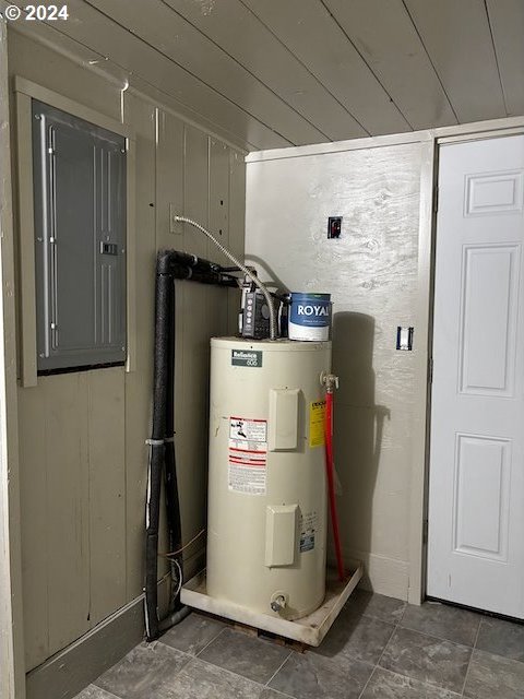 utility room with electric panel and water heater