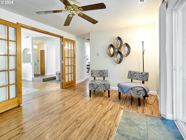 sitting room featuring ceiling fan, a textured ceiling, and light hardwood / wood-style floors