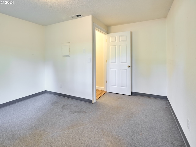 spare room featuring a textured ceiling and carpet floors