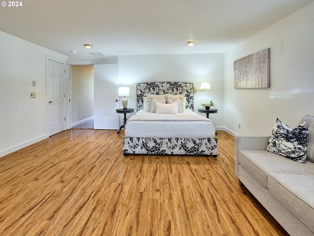 bedroom featuring light hardwood / wood-style flooring and a textured ceiling