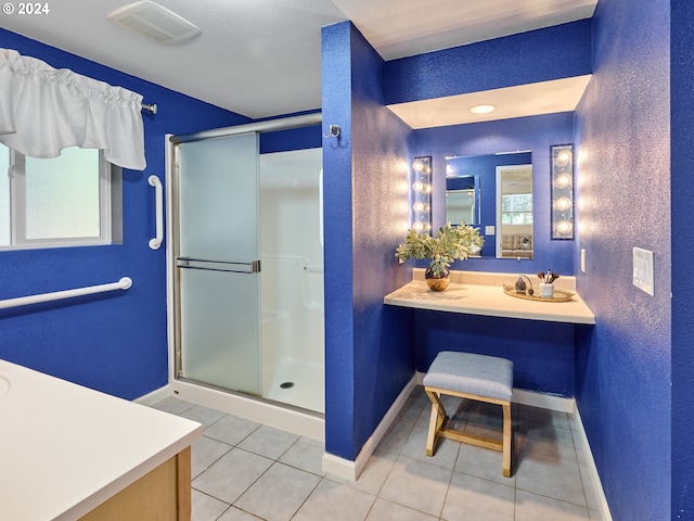 bathroom with walk in shower, vanity, and tile patterned floors